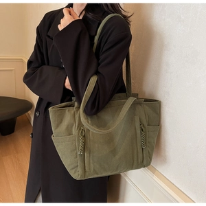 Vista dettagliata della borsa tote in velluto a coste verde oliva con tasche laterali