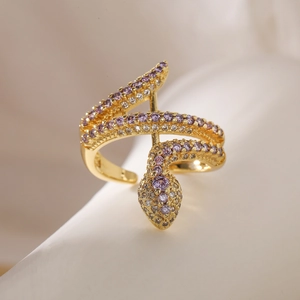Macro shot of gold snake ring with sparkling purple and white cubic zirconia crystals