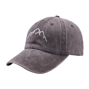 Detail of embroidered mountain logo on vintage washed grey cotton baseball cap