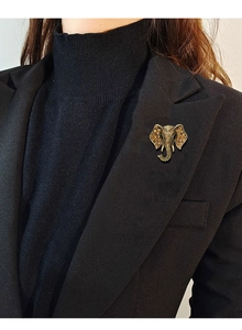 Detail of vintage elephant brooch with amber rhinestones pinned on a black suit lapel