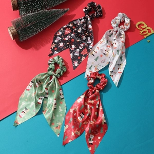 Set of four satin Christmas scrunchies with long streamers in festive colors and holiday prints
