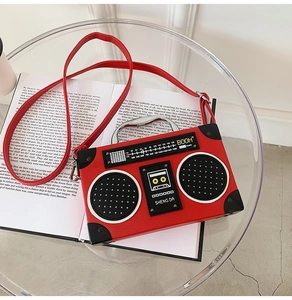 Top view of creative red radio box bag with cassette print on a vintage open book