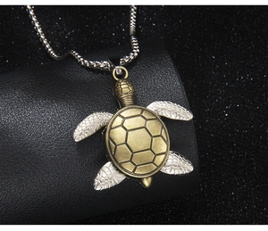 Macro detail of a vintage turtle pendant with bronze shell and silver box chain