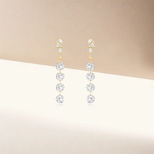 Close-up of gold S925 silver long tassel earrings with sparkling round and teardrop stones