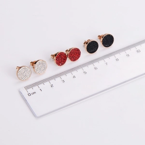Three pairs of round stainless steel stud earrings in white, red, and black with ruler