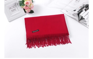 Detail of red cashmere scarf with elegant fringe texture and soft solid color weave