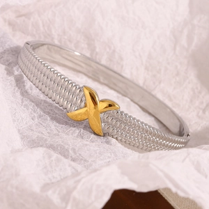 Detailed macro view of silver and 18K gold two-tone X-shaped hinge bangle bracelet