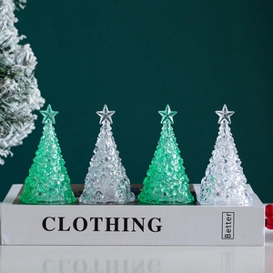 Mini glowing crystal Christmas trees with star tops on decorative book for holiday desk decor