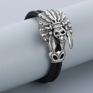 Detail of silver stainless steel Indian skull charm on black braided leather bracelet