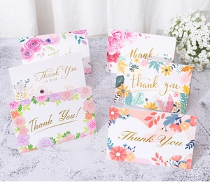Detail of floral Thank You cards with gold foil lettering on marble surface