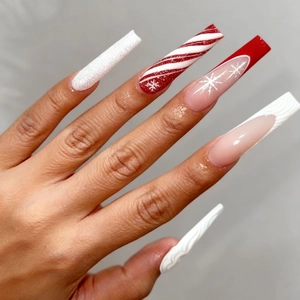 Macro shot of extra-long square press-on nails featuring red and white Christmas designs