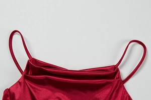 Detail of burgundy satin evening dress featuring delicate thin straps and elegant cowl neck