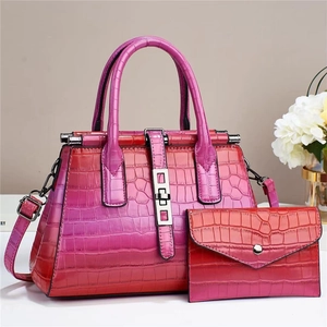 Detail of crocodile embossed faux leather handbag with red gradient finish and metal lock