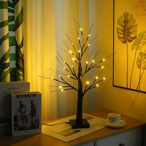 Detail view of a warm LED birch tree light on a square black base with USB cable