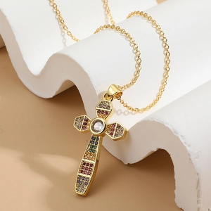 Luxurious gold-plated cross pendant necklace with colorful cubic zirconia on white wave stand