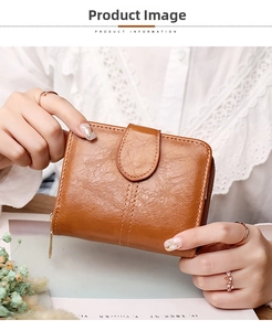Close-up of caramel leather wallet with lychee grain texture and gold zipper detail