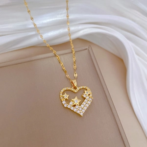 Golden heart and star pendant necklace with zircons on elegant silk background