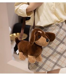 Detail of plush dachshund dog shoulder bag shown on model with adjustable strap