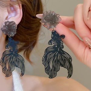 Close-up detail of hollow goldfish drop earrings with translucent resin flower accents
