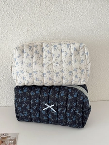 Quilted floral makeup bags with bow details and metal zippers in navy and cream