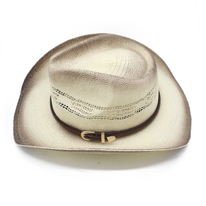Detail of western straw cowboy hat with brown leather band and gold horseshoe buckle