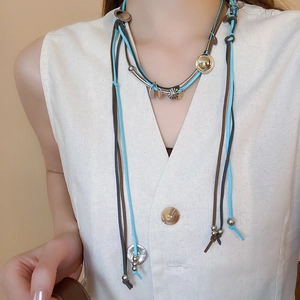 Detailed close-up of Bohemian layered suede necklace with blue and brown braided cords