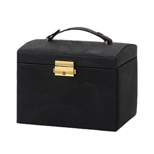 Three-layer black textured jewelry box with gold lock and handle on white background