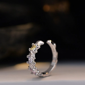 Polished silver ear cuff with irregular lava texture and three colored square zircons