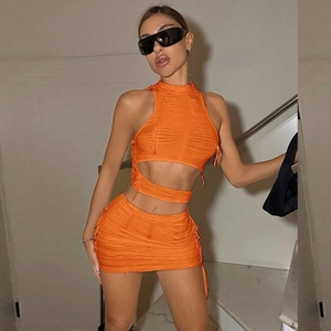 Dettaglio del set in maglia arancione con top a fascia e gonna a costine con coulisse