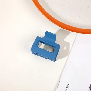 Close-up of a matte Morandi blue square hollow hair claw clip on a modern lifestyle set