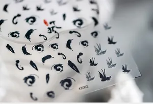 Detailed macro view of ink-wash style nail stickers with swallow and swirl patterns