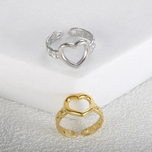 Close-up of gold and silver open rings with hollow heart design and chain texture