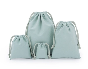 Set of four light green drawstring fabric bags in various sizes on white background