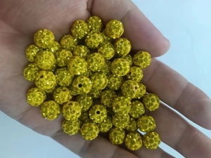 Macro shot of 10mm yellow crystal pave clay beads for DIY bracelet jewelry making