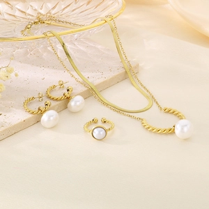 Detailed close-up of gold pearl jewelry set on elegant silk and stone background