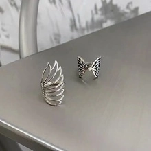 Macro detail of retro 925 silver rings with wing and butterfly patterns on metal surface