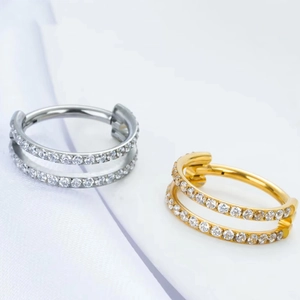 Detail of titanium double layered hinged ring with inlaid cubic zirconia in gold and silver