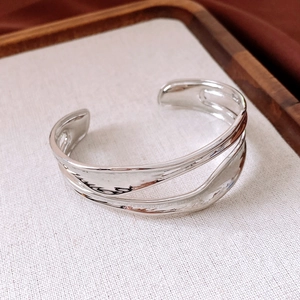 Macro di bracciale a doppia fascia argentata con design a onde e finitura lucida