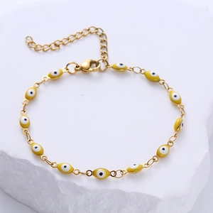 Golden stainless steel chain bracelet featuring yellow evil eye beads and lobster clasp