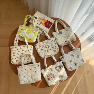 Top view of seven quilted cotton mini tote bags with various cute animal and floral prints