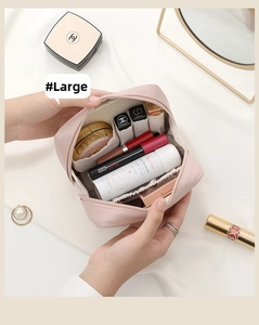 Large pale pink leather makeup bag interior with multiple compartments and open zipper