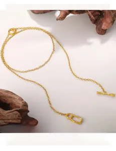 Close-up of golden anchor link necklace with T-bar toggle closure on wooden background