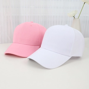 Minimalist pink and white cotton baseball caps displayed in a clean, natural setting