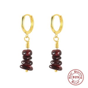 Macro detail of S925 sterling silver earrings with irregular dark red natural stone drops