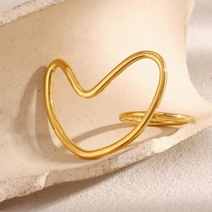 Detailed close-up of a 18K gold-plated minimalist heart outline ring on a stone display