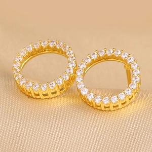 Gold plated circular hoop earrings with micro-pave white zircon on satin background