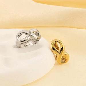Detail shot of 18k gold and silver infinity rings on a white and yellow background