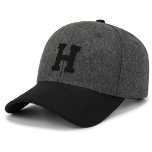 Detail of grey wool texture baseball cap with black curved brim and H embroidery