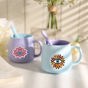 Detail showing bohemian evil eye stickers on ceramic mugs with floral lotus designs