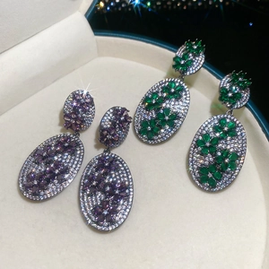 Close-up of vintage flower oval stud earrings with purple and green zircon petals